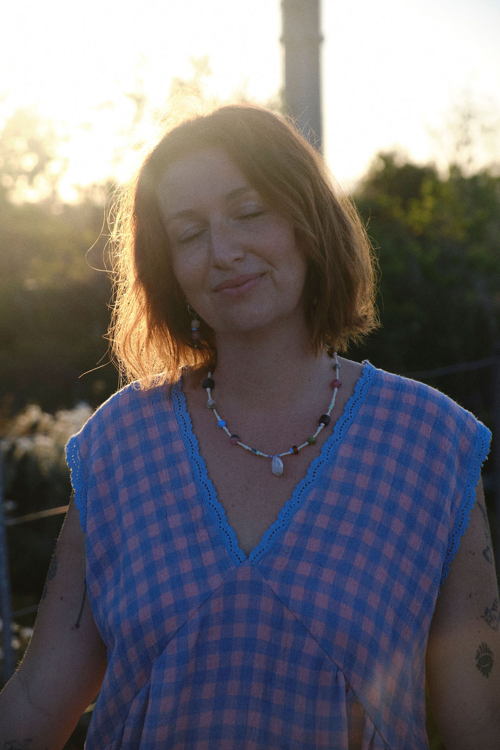 Amilita Haze Necklace – handmade beaded necklace with shell pendant, styled with Sunset Haze gingham